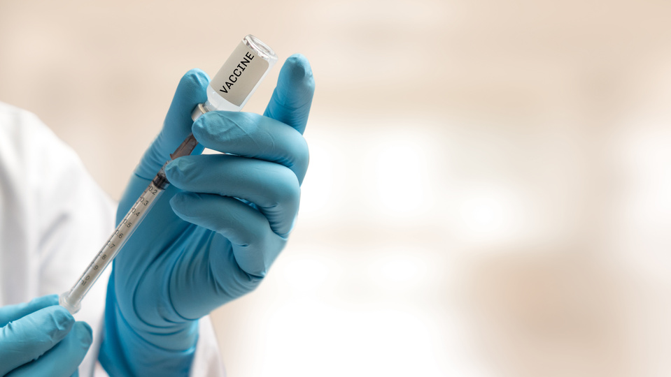 Covid-19 vaccine concept. Hand of doctor in medical gloves with syringe and vaccination bottle in hospital laboratory for new coronavirus disease